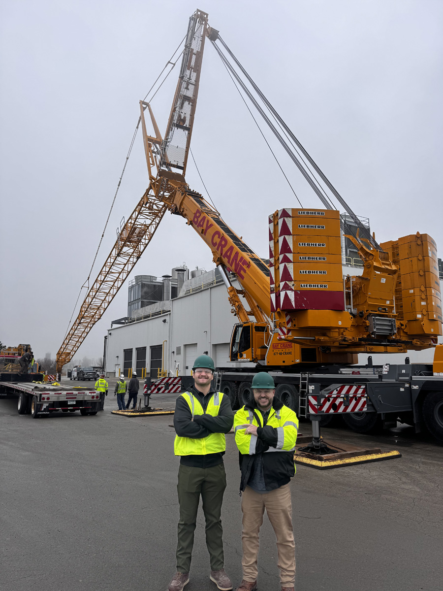 2 people standing by a crane